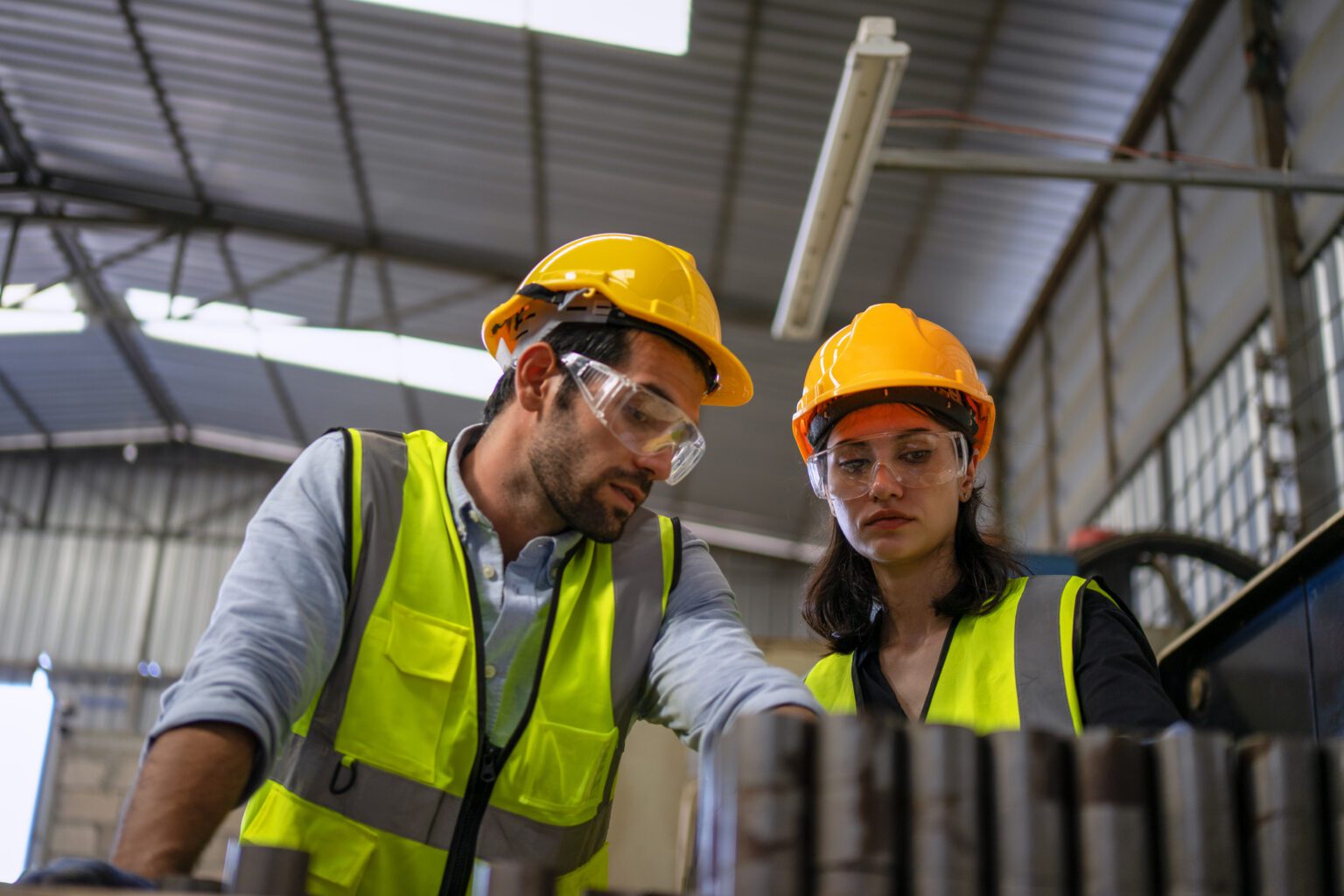 Workers in High Visibility Vests and PPE Inspecting Equipment