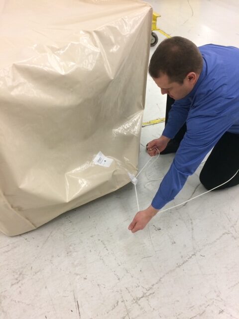 Man Fitting a Cover on a Pallet