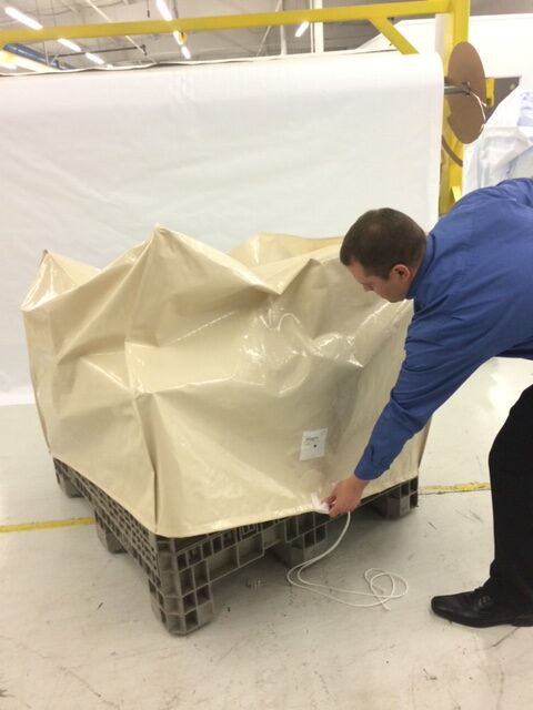 Man Putting a Protective Cover on a Pallet