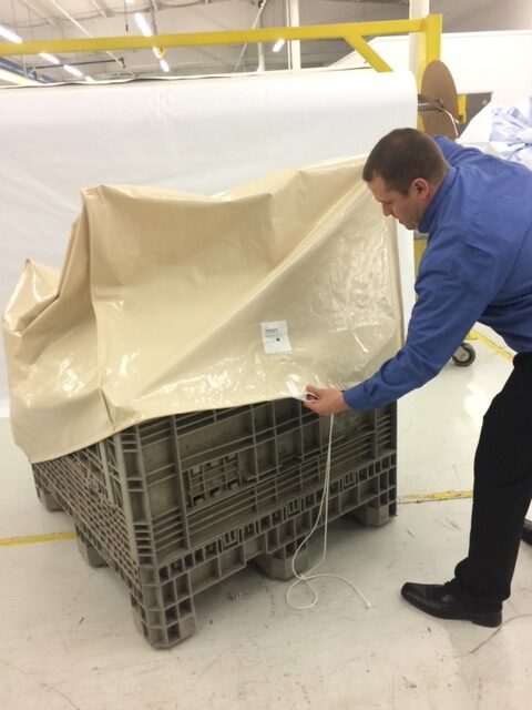 Man Starting to Put a Cover on a Pallet