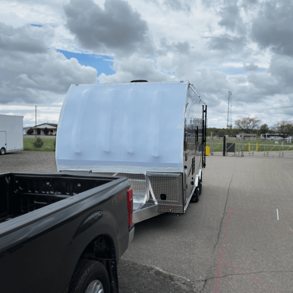 Covered RV getting towed by Truck