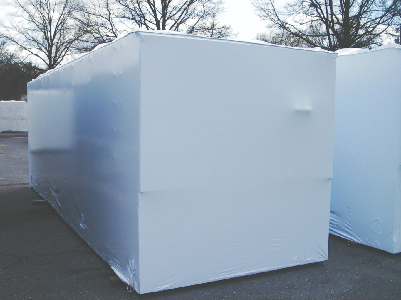 large piece of equipment being stored outside and  wrapped in a transhield shrinkable cover
