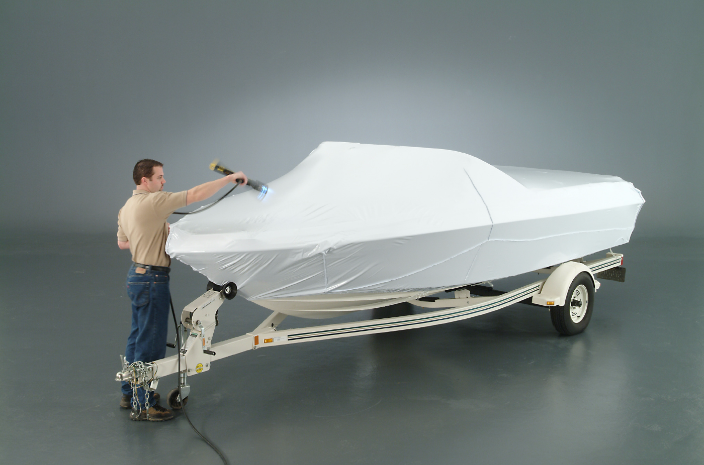 man heat shrinking a transhield cover on a boat